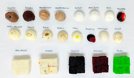 A cake tasting board with handwritten labels showing rows of filling and icing samples plus squares of white, vanilla, chocolate, red velvet, and pistachio cake.