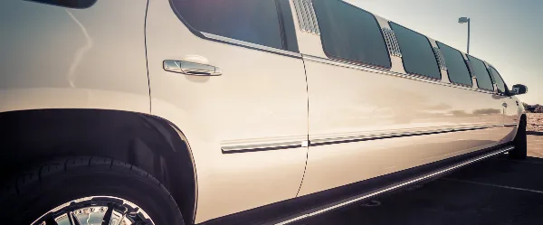 A white stretch limousine parked in a lot.