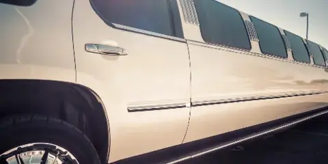 A white stretch limousine parked in a lot.