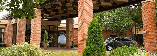 Exterior view of the Lake Okoboji Resort & Conference Center entrance with brick columns and landscaping.