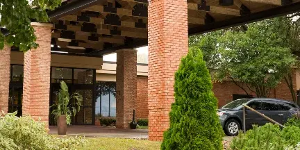 Exterior view of the Lake Okoboji Resort & Conference Center entrance with brick columns and landscaping.