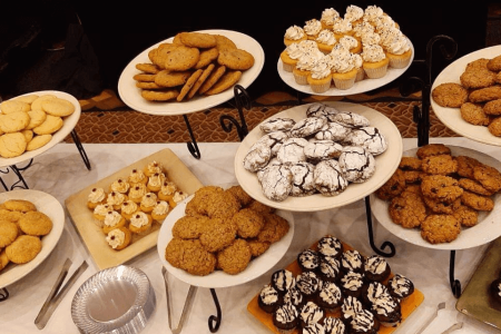 Tiered display of assorted cookies, cupcakes, and baked desserts arranged for a catering event.