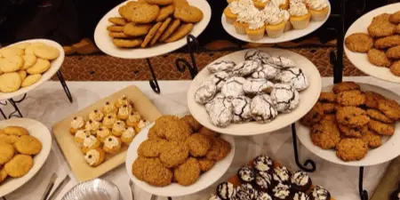 Tiered display of assorted cookies, cupcakes, and baked desserts arranged for a catering event.