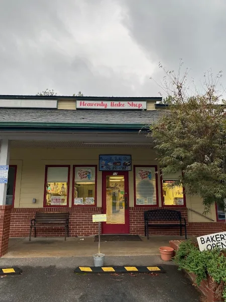 Exterior view of the Heavenly Bake Shop storefront with red doors and signage.