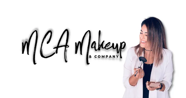 A professional makeup artist smiling while holding a makeup brush and a compact.
