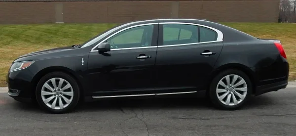 A black Lincoln luxury sedan parked on a paved surface.