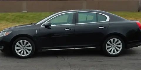 A black Lincoln luxury sedan parked on a paved surface.