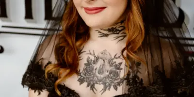Portrait of a bride with styled hair and makeup, wearing a black lace dress and tiara.