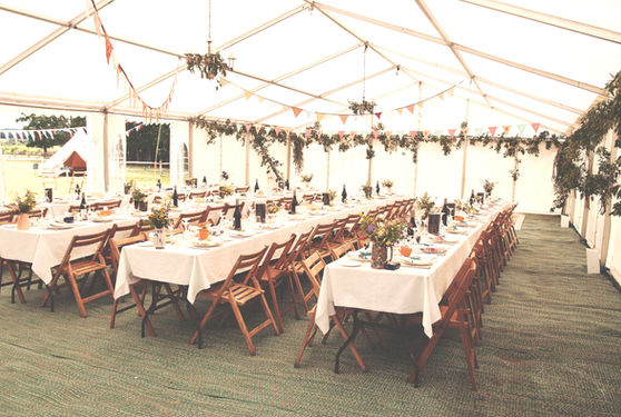 A banquet hall set up for an event with long tables, white tablecloths, and floral centerpieces.