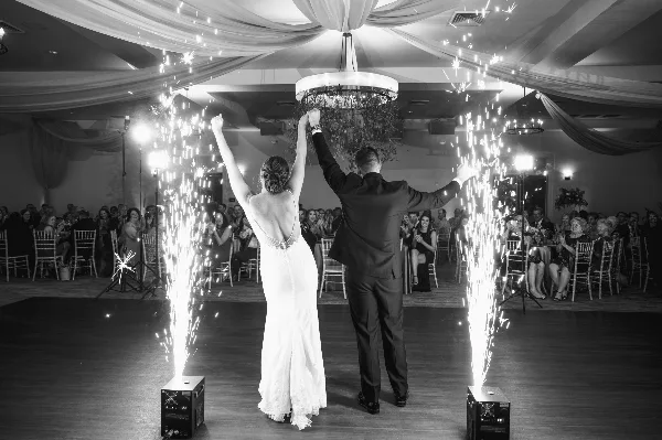 A bride and groom perform a sparkler exit on a dance floor during a wedding reception.