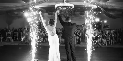 A bride and groom perform a sparkler exit on a dance floor during a wedding reception.
