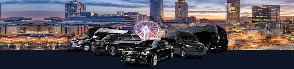 A lineup of black luxury vehicles including a sedan, SUV, and van parked in front of a city skyline at dusk.