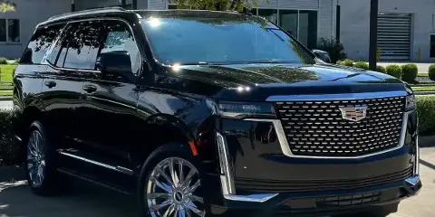 A black Cadillac SUV parked outdoors, representing the vehicle fleet of the limo service.