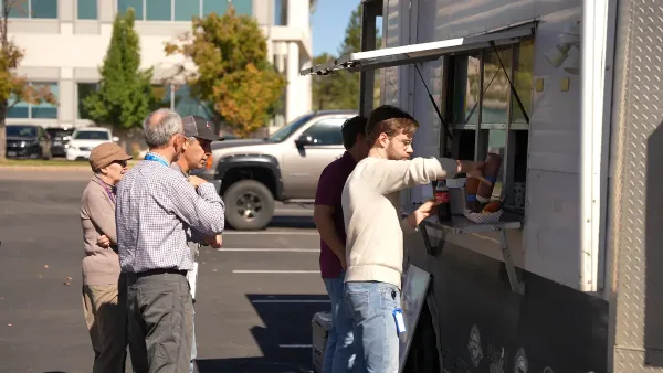 A food truck serving customers in a parking lot.