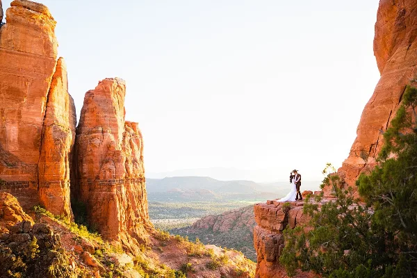 A couple poses at the top of Cathedral Rock in Sedona, captured by Arizona wedding photographer Juniper and Co Photo.