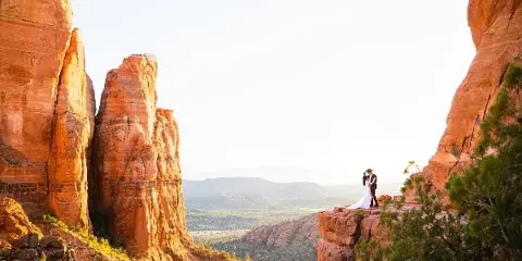 A couple poses at the top of Cathedral Rock in Sedona, captured by Arizona wedding photographer Juniper and Co Photo.