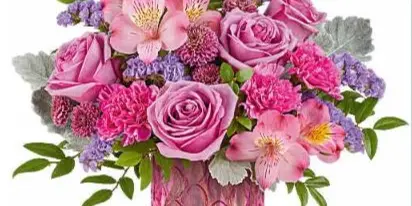 A vibrant floral arrangement featuring pink roses, alstroemeria, and purple filler flowers in a textured pink vase.