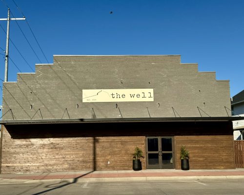 Exterior view of The Well Event Center building featuring a distinctive stepped roofline and brick facade.