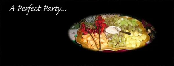 A catering platter featuring an assortment of fresh fruit including strawberries, grapes, and melon with a central dip.