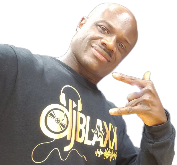 Portrait of a smiling man making a hand gesture, wearing a black shirt with a gold DJBlaxx logo and turntable graphic.