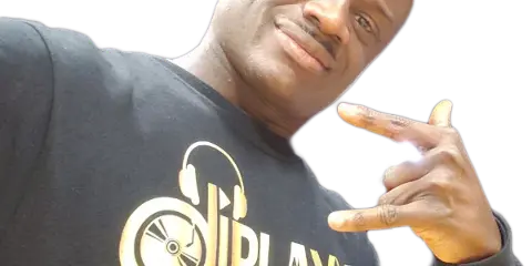 Portrait of a smiling man making a hand gesture, wearing a black shirt with a gold DJBlaxx logo and turntable graphic.