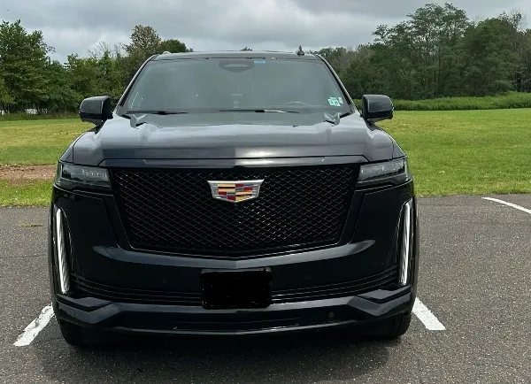Front view of a black Cadillac Escalade luxury SUV parked in a lot.