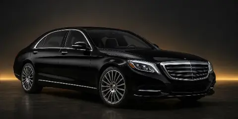 Black luxury sedan parked in a studio setting