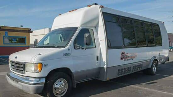 White shuttle bus with Bakersfield Party Buses branding parked in a lot