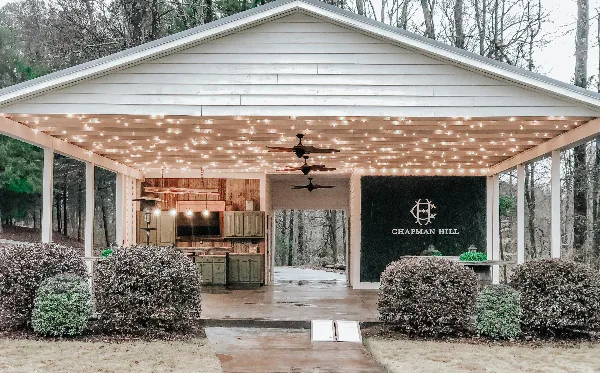 Exterior view of the Chapman Hill Events wedding venue pavilion with string lights and outdoor kitchen.