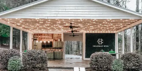 Exterior view of the Chapman Hill Events wedding venue pavilion with string lights and outdoor kitchen.
