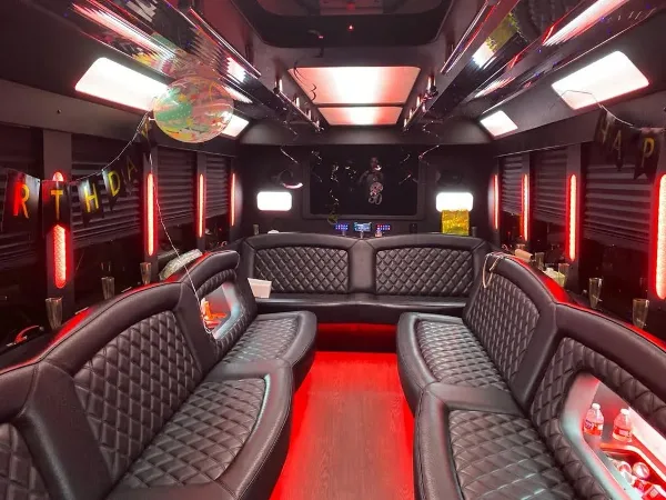 Interior of a party bus with black leather seating and red LED lighting