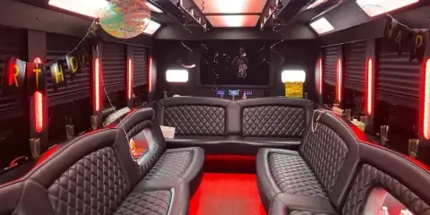 Interior of a party bus with black leather seating and red LED lighting