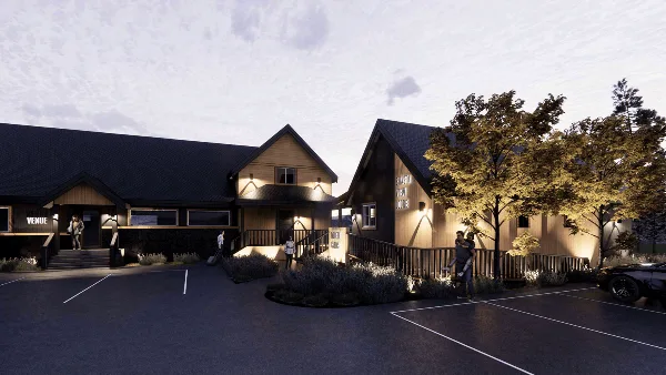 Exterior view of Shasta View Lodge cabins and venue building at dusk with people walking near the entrance.