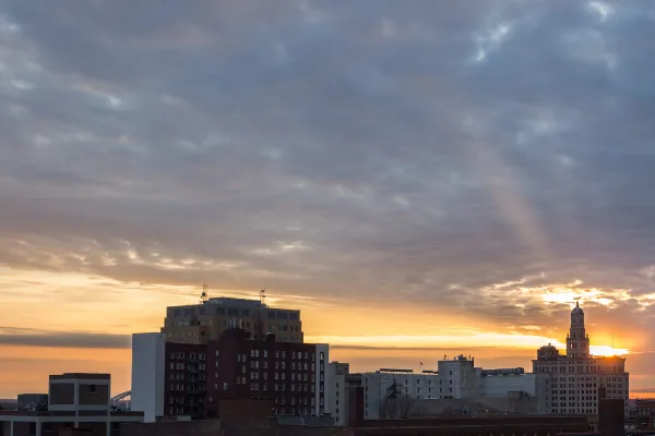 Sunset view of the Davenport, Iowa city skyline featuring the historic clock tower and surrounding buildings.