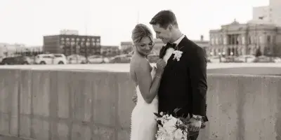 A black and white photograph of a bride and groom standing together outdoors.
