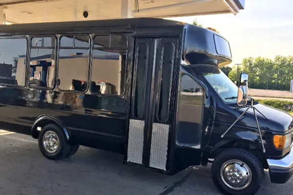 A black shuttle bus parked outdoors.