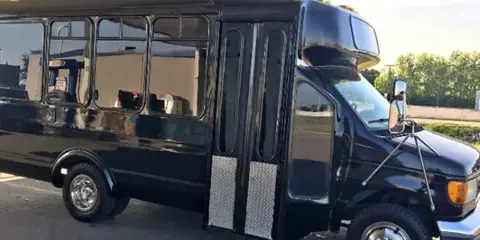 A black shuttle bus parked outdoors.
