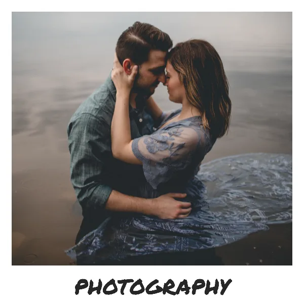 A professional engagement photograph of a couple embracing near a body of water, with the word 'PHOTOGRAPHY' displayed at the bottom.
