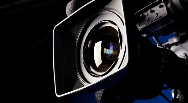 Close-up of a professional video camera lens and equipment.