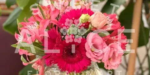Pink mixed flower bouquet in a clear glass vase