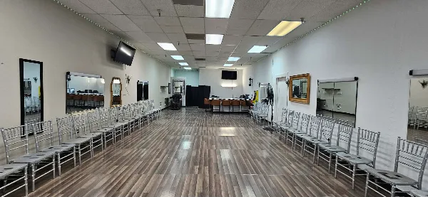 Interior view of an event space with rows of silver chairs arranged for a ceremony.