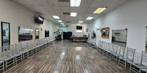 Interior view of an event space with rows of silver chairs arranged for a ceremony.