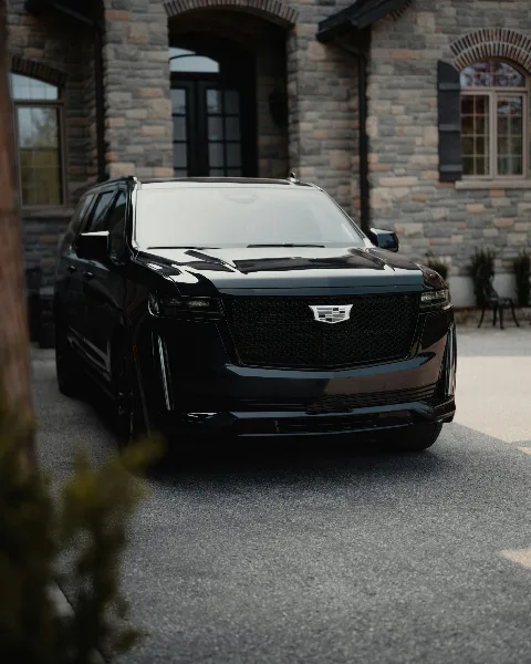 A black luxury SUV parked in front of a stone building