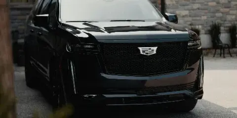 A black luxury SUV parked in front of a stone building