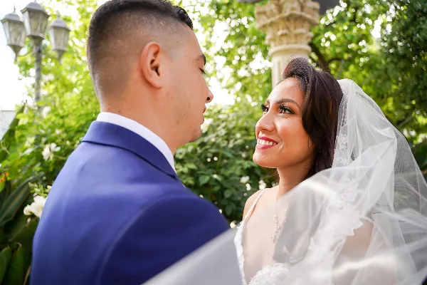 A bride and groom looking at each other during a wedding ceremony outdoors.