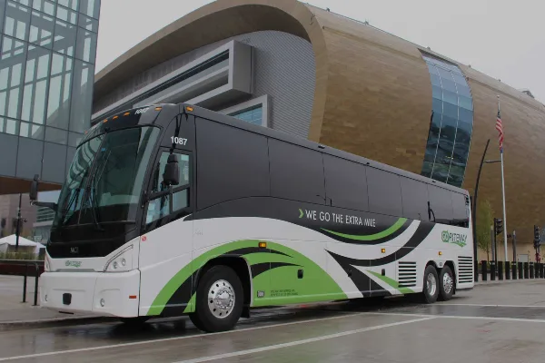 A GO Riteway motorcoach parked in front of a modern building.