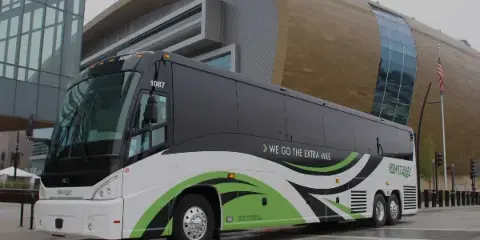 A GO Riteway motorcoach parked in front of a modern building.