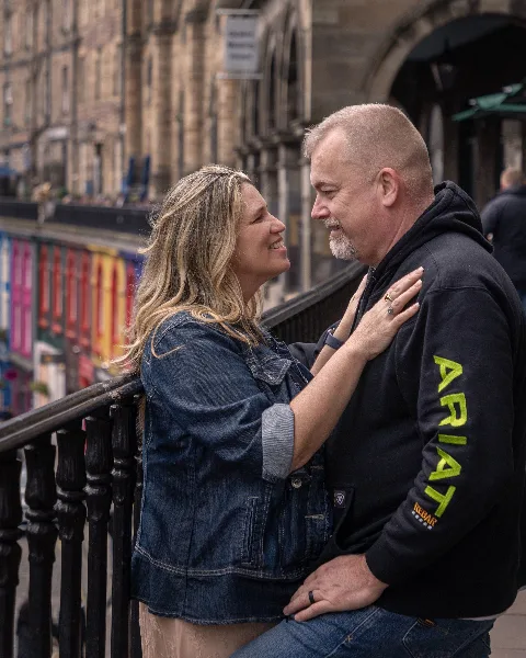 A smiling couple posing together outdoors in a portrait photography session.