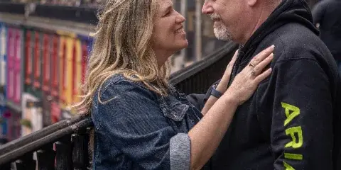 A smiling couple posing together outdoors in a portrait photography session.