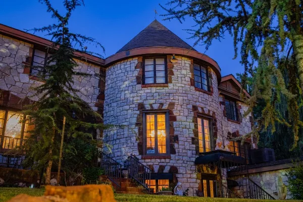 Exterior view of the stone castle building at Castle Falls venue at dusk.